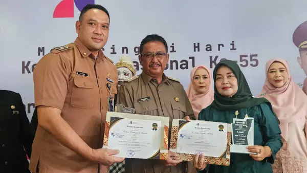 Kepala Bapenda Kabupaten Sukabumi, Herdy Somantri dan pegawai Bapenda Ibu Levi saat menerima penghargaan dari Bupati Asep Japar pada ajang AAI Award 2026, Senin (15/6/2026). (Sumber Foto: Istimewa)