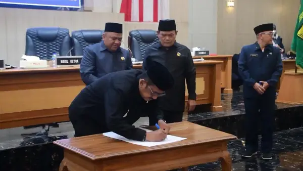 Bupati Sukabumi Asep Japar saat menandatangani berkas persetujuan Raperda pertanggungjawaban APBD 2025 di Rapat Paripurna. (Sumber : Diskominfosan Kab. Sukabumi)
