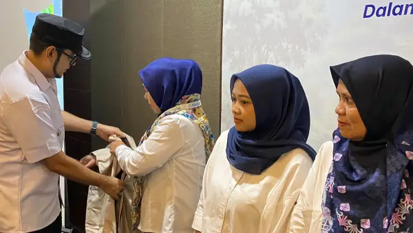 Wakil Wali Kota Sukabumi, Bobby Maulana mengenakan rompi kepada salah satu agen perisai BPJS Ketenagakerjaan. (Sumber : dokpim)