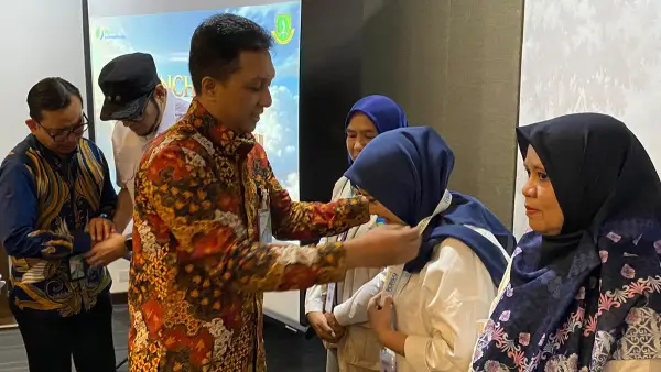 Kepala BPJS Ketenagakerjaan Cabang Sukabumi, Alpian saat menyematkan lencana secara simbolis kepada salah satu agen perisai. (Sumber: BPJS Ketenagakerjaan)