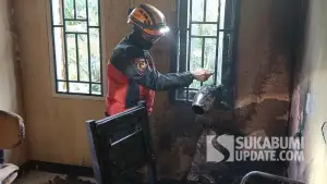 Petugas menunjukkan teko pemanas air yang ditemukan di ruang staf lantai dua Kantor Desa Balekambang, Kecamatan Nagrak, Kabupaten Sukabumi, pascakebakaran, Kamis (9/7/2026). (Sumber Foto: Istimewa)