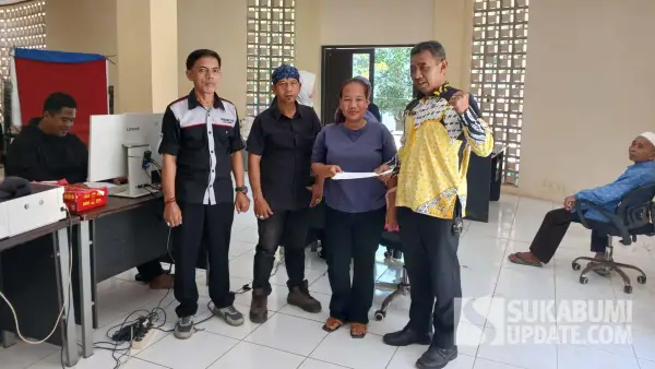 Plt Kepala UPTD Dukcapil Surade bersama petugas dan warga di stan pelayanan Adminduk Disdukcapil Kabupaten Sukabumi pada rangkaian Syukuran Nelayan Minajaya ke-14 . (Sumber Foto: SU/Ragil)