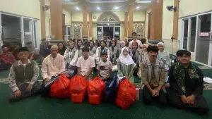 Mahasiswa KKN LPCR F-PCM Jampangtengah UMMI berfoto bersama anak-anak yatim, pengurus PCM Jampangtengah, dan KL Lazismu Jampangtengah usai kegiatan santunan di Masjid Al-Falaah. (Sumber Foto: Dok. KKN UMMI)