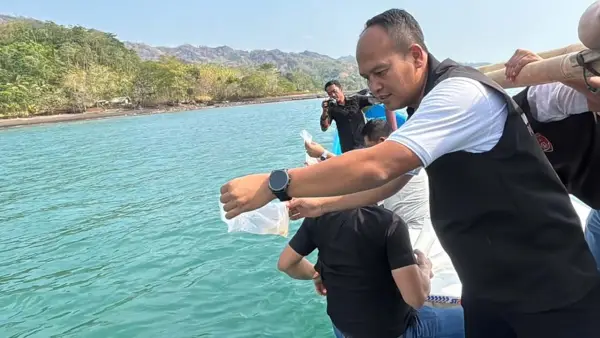 Kasatreskrim Polres Sukabumi, Iptu Dudi Suharyana saat melepasliarkan benur hasil pengungkapan kasus penyelundupan. (Sumber Foto: Dok. Polres Sukabumi)