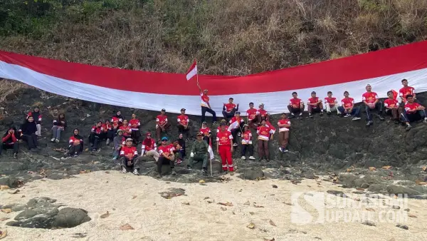 Peserta Susur Pantai ke-12 membentangkan Bendera Merah Putih sepanjang 28 meter di kawasan Pulau Keris Sukabumi dalam rangka memperingati HUT ke-81 RI. (Sumber Foto: Istimewa)