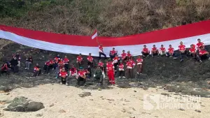 Peserta Susur Pantai ke-12 membentangkan Bendera Merah Putih sepanjang 28 meter di kawasan Pulau Keris Sukabumi dalam rangka memperingati HUT ke-81 RI. (Sumber Foto: Istimewa)