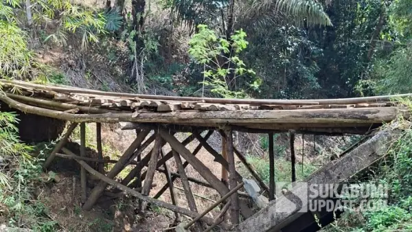 Kondisi jembatan dari kayu dan bambu sebagai pengganti jembatan permanen yang hancur akibat banjir pada 2024 di Desa Tegallega, Kecamatan Lengkong, Kabupaten Sukabumi. | Foto: SU/Ragil Gilang