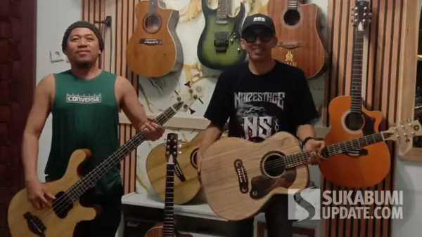 Naink (berkaus singlet hijau) bersama Ryan seniman Geopark Ciletuh Kabupaten Sukabumi, menunjukkan gitar handmade berbahan kayu pilihan yang diproduksinya secara manual di rumah. (Sumber Foto: Dokumentasi Pribadi)