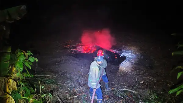 Petugas Damkar Posko V Cibadak bersama unsur terkait saat padamkan api di lahan limbah kayu di Kampung Pondok Anyar RT 01/RW 04, Desa Tenjojaya, Kecamatan Cibadak, Kabupaten Sukabumi, Rabu (16/9/2026) malam. (Sumber : Istimewa.)
