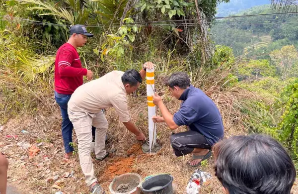 Pemasangan reflektor jalan bantuan mahasiswa KKN Nusa Putra di Desa Cikarae Thoyyibah. (Sumber Foto: Istimewa)