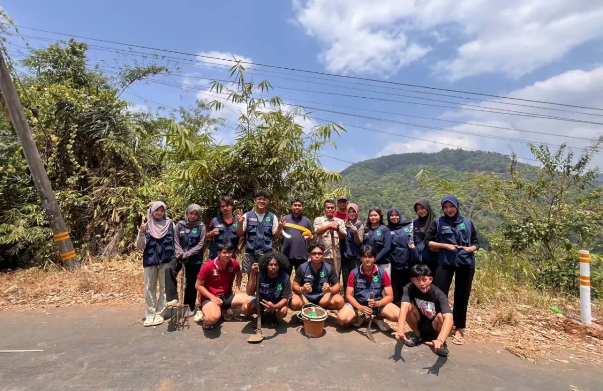 Mahasiswa KKN berfoto bersama dengan reflektor jalan yang sudah terpasang.