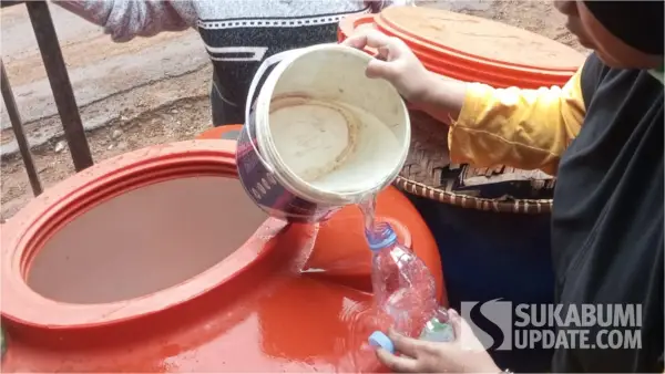 Petugas puskesmas saat mengambil sampel air tadah hujan yang diduga jadi penyebab diare massal di Desa Cikujang Gunungguruh Sukabumi. (Sumber: SU/Asep Awaludin)