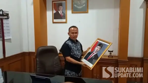 Wakil Ketua DPRD Kota Sukabumi, Rojab Asyari saat menurunkan foto Wapres Gibran di ruangan kerjanya, Rabu (7/10/2026). (Sumber Foto: SU/Asep Awaludin)
