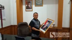 Wakil Ketua DPRD Kota Sukabumi, Rojab Asyari saat menurunkan foto Wapres Gibran di ruangan kerjanya, Rabu (7/10/2026). (Sumber Foto: SU/Asep Awaludin)