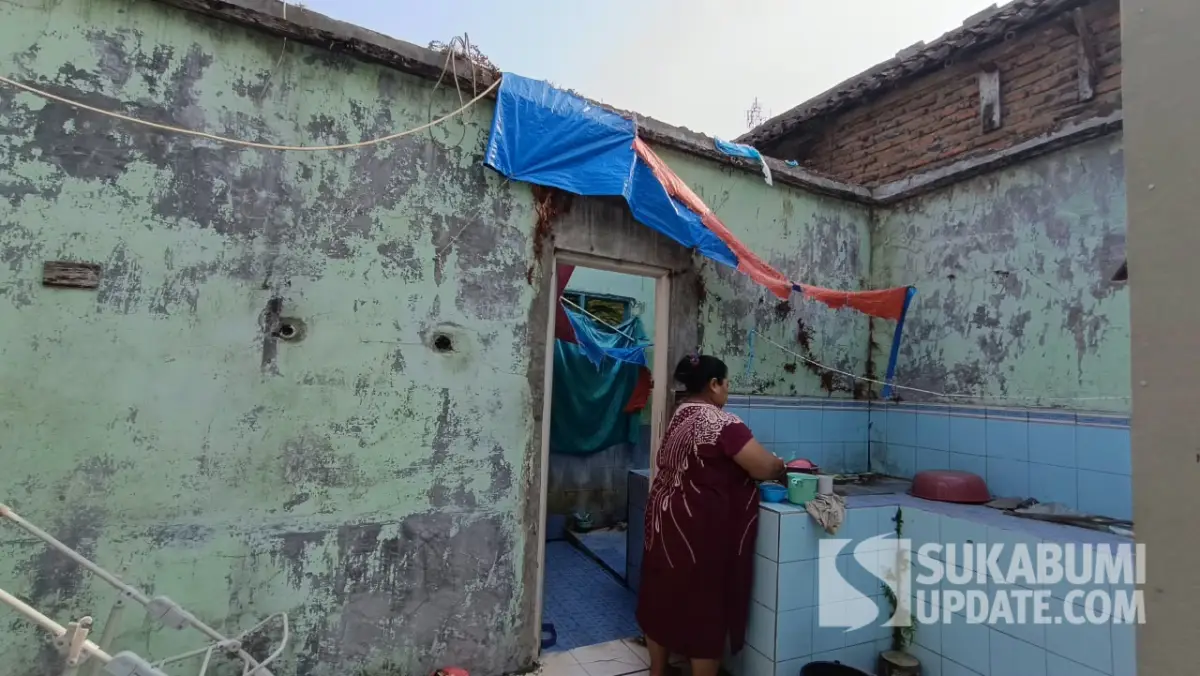 Herti (46 tahun), berdiri di rumahnya yang ambruk akibat dampak gempa bumi pada 2024. | Foto: SU/Ilyas Supendi