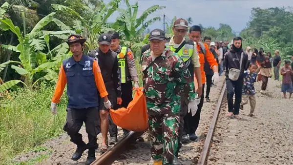 Jenazah Sandi (40) saat dievakuasi oleh petugas kepolisian bersama petugas KAI dan anggota TNI, usai tertemper Kereta Api (KA) Pangrango, Sabtu (24/10/2026). (Sumber : Istimewa.)